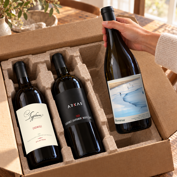 Illustrative three-bottle wine unboxing with Cabernet Sauvignon and Chardonnay bottles