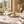 Illustrative still white wine served with bread, cheese and herbs at a sunlit table