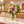 Illustrative bouquet in a decorative vase beside an elongated Flower of the Month Club branded shipping box