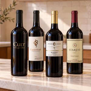 Illustrative 4 distinct red wines arranged on marble; actual selections vary