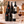 Illustrative six-bottle red wine selection on a rectangular marble platform with a branded shipping box behind the bottles